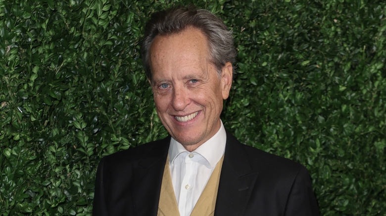 Richard E. Grant wearing gold vest