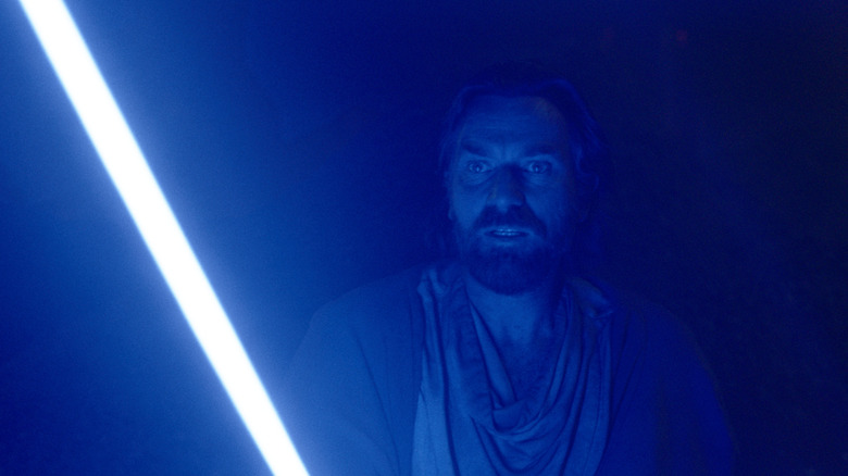 Obi-Wan in glow of blue lightsaber