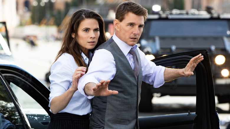 Ethan Hunt and Grace standing in front of car