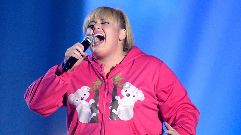 Rebel Wilson singing in pink koala hoodie