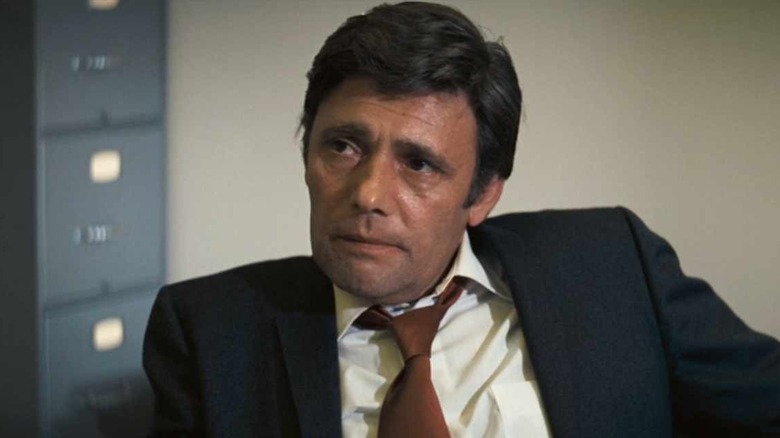 Harry Guardino sits at a desk