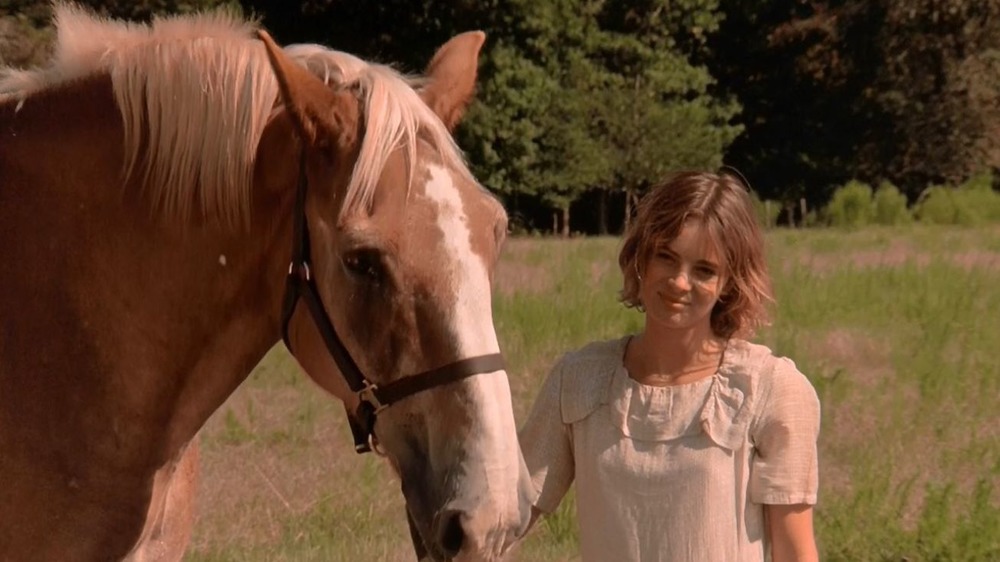 Woman stands with horse