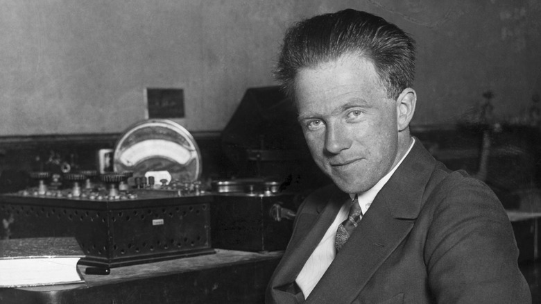 Werner Heisenberg sits at a desk