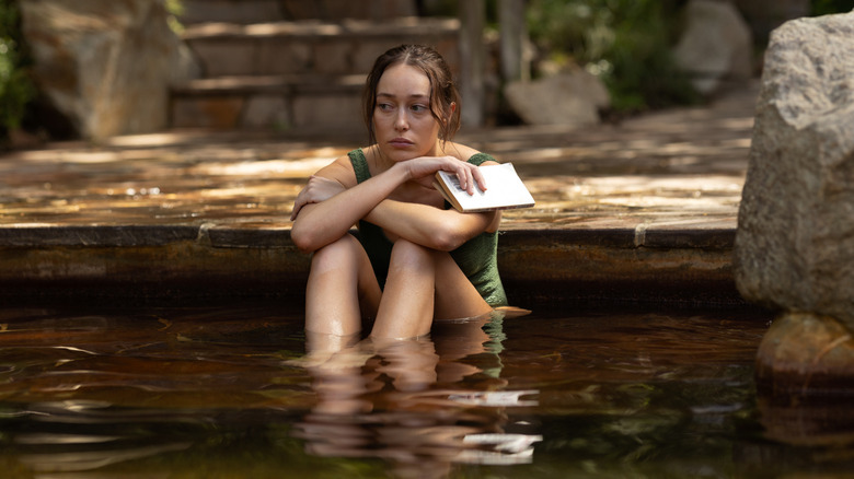 Milla sitting in a pool in "Apple Cider Vinegar."