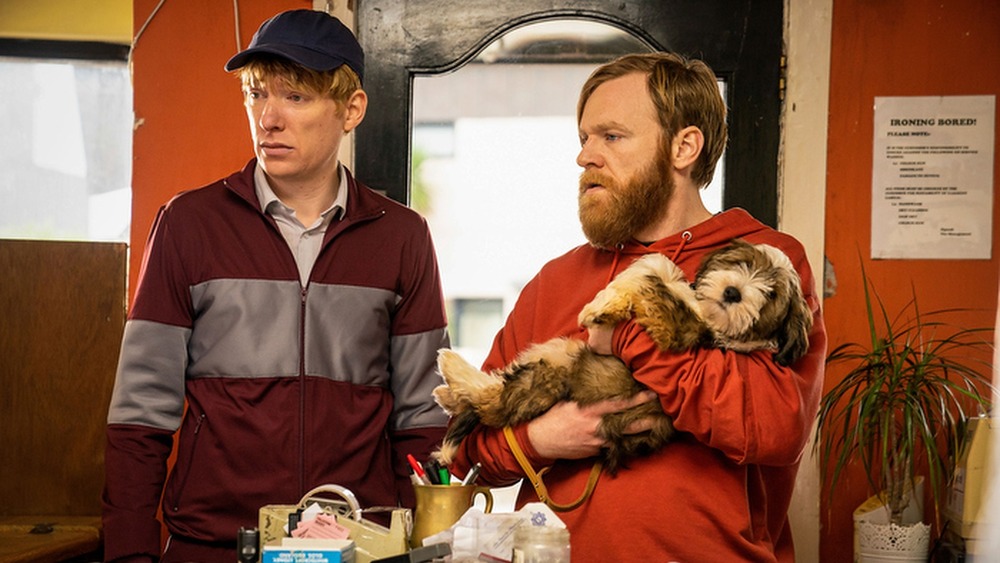 Frank holds a dog next to Doofus