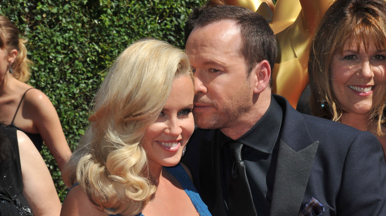 Donnie Wahlberg whispering in Jenny McCarthy's ear on the red carpet