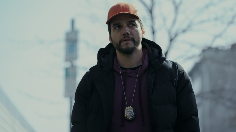 Manny standing in the street, wearing a badge