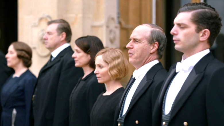 The Downton Abbey staff stands in a line