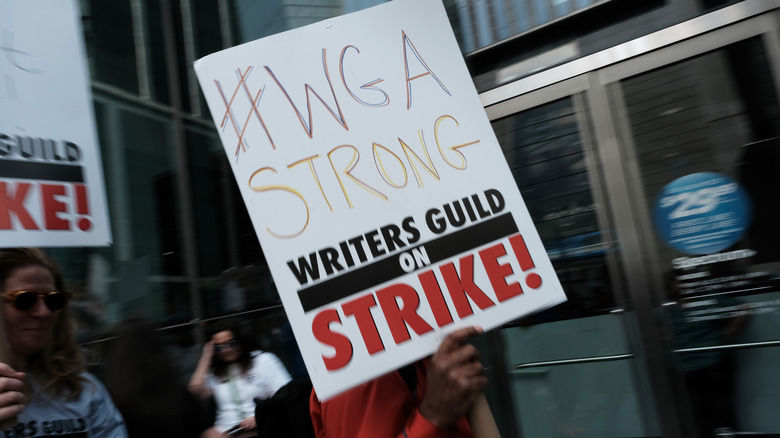 A striking WGA holds a picket sign