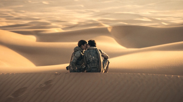 Chani and Paul kiss on a sand dune