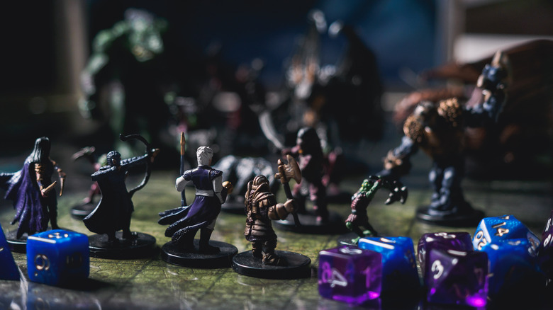 A group of miniatures on a game board with dice