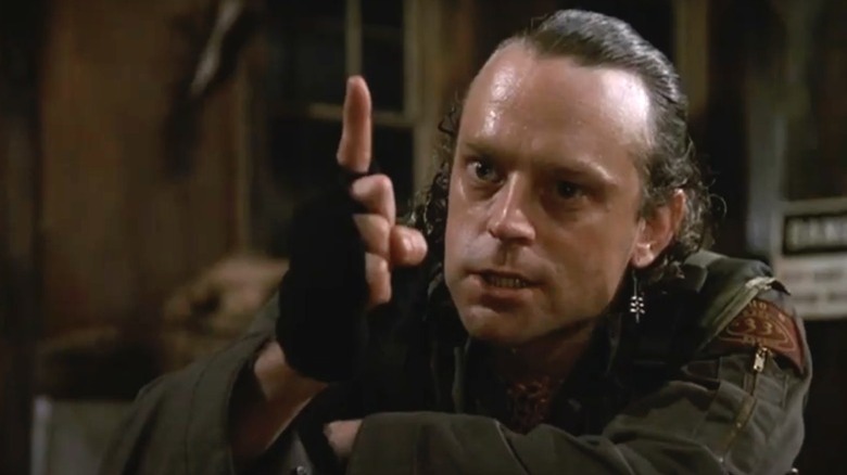 Brad Dourif holding up a finger threateningly