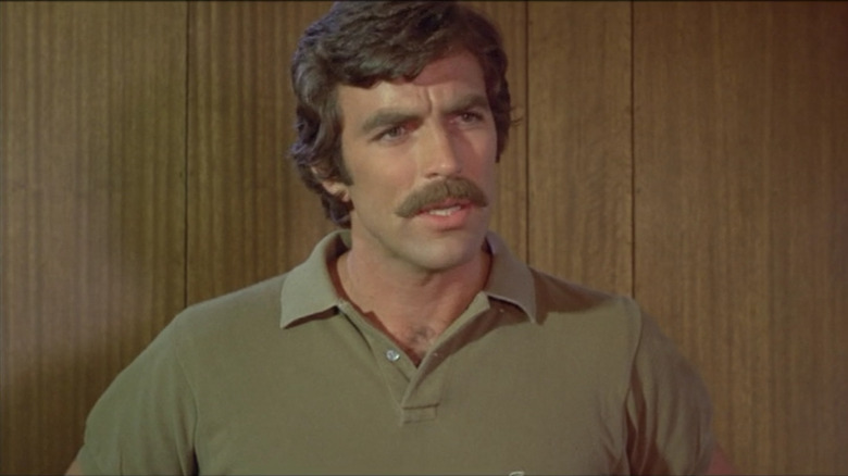 Tom Selleck in front of wood paneling