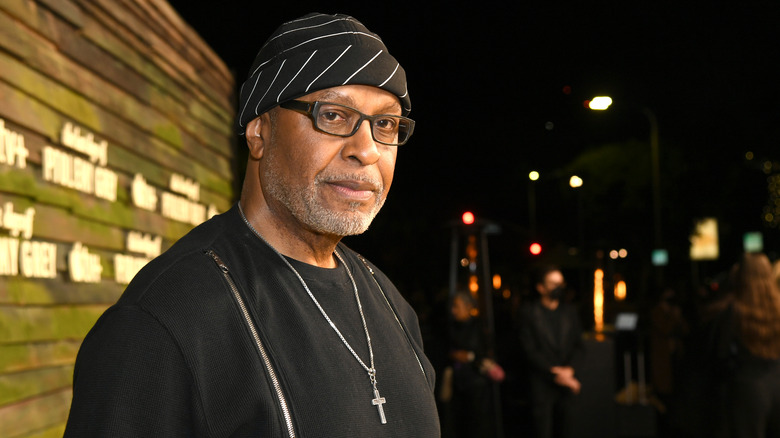 James Pickens Jr., in hat and glasses, turns his head 