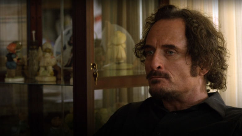 Tig sitting in room of dolls