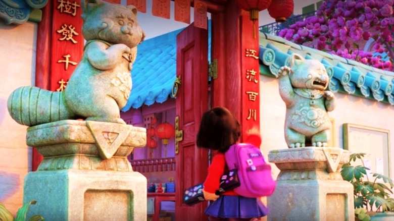 Mei walks between two statues