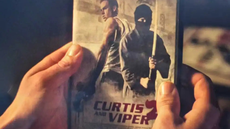 Joel holding Curtis and Viper 2 DVD