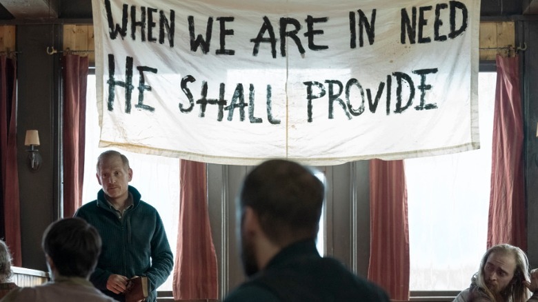 David standing beneath a banner