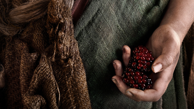 A Harfoot holding berries