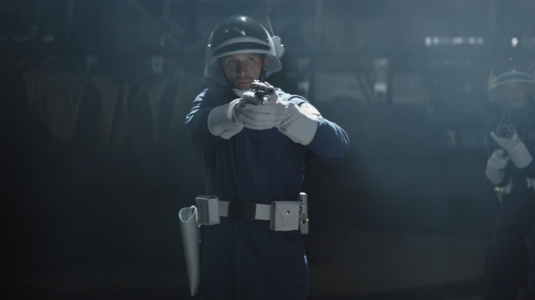 A rebel guard points a blaster