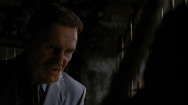 Ra's al Ghul talks to Bruce Wayne in the shadows