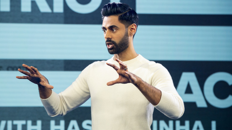 Hasan Minhaj gesticulating while hosting