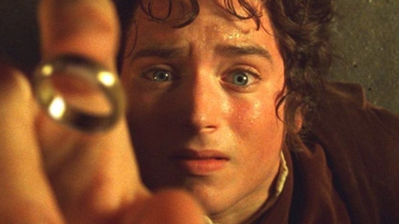 Frodo grasps at the Ring