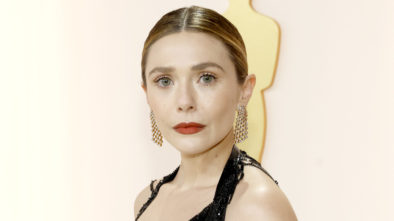 Elizabeth Olsen wearing large earrings and red lipstick