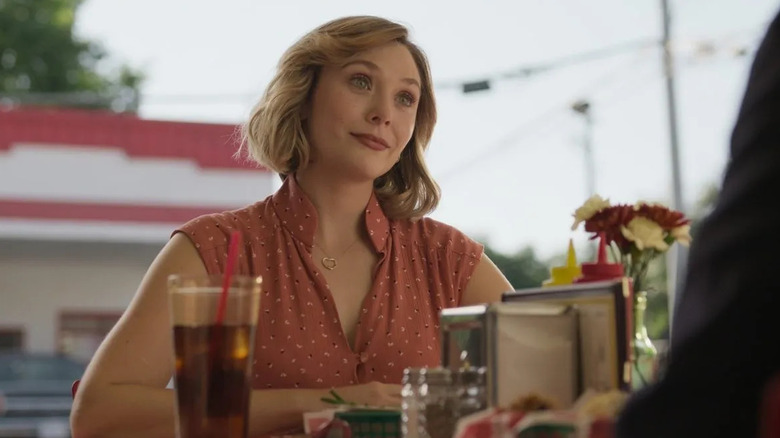 Elizabeth Olsen seated at outdoor table