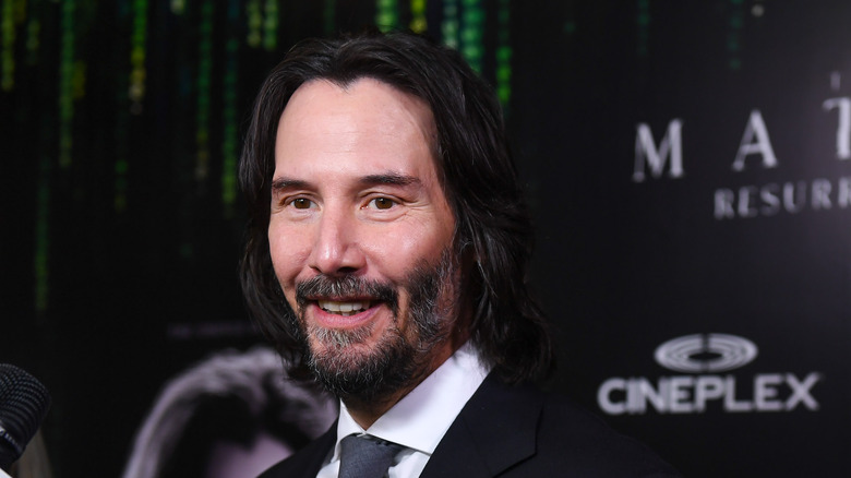 Keanu Reeves smiling at the premiere of The Matrix: Resurrections