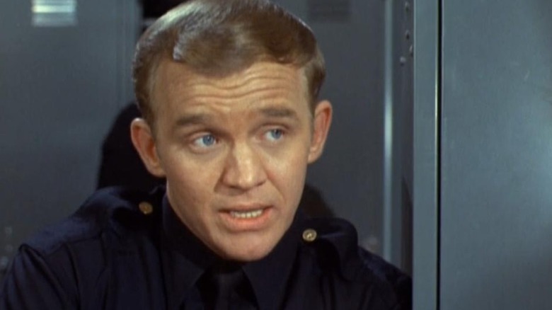 Officer Ed Wells leans on a locker