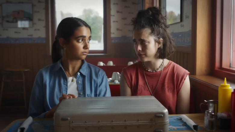 Margaret Qualley and Geraldine Viswanathan with briefcase