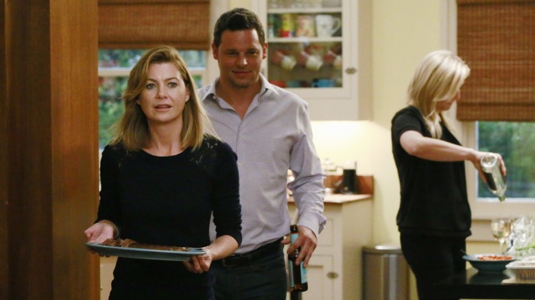 Meredith carrying plate next to Alex