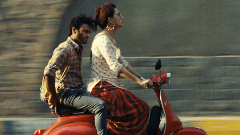 Haider and Biba ride a motorcycle