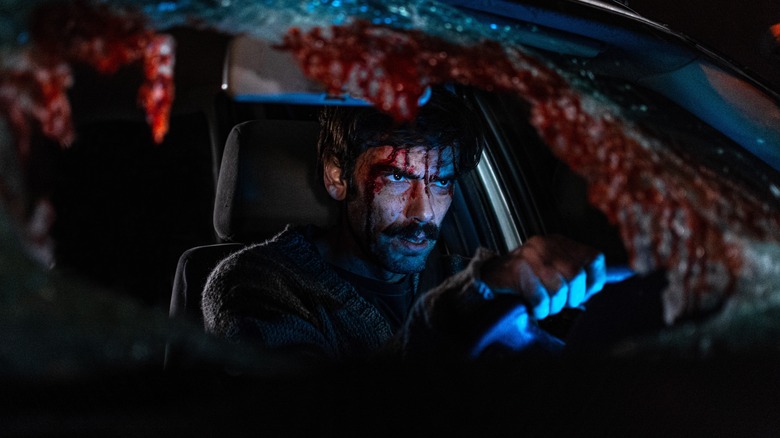 Man seated in smashed-up car