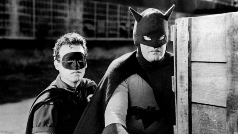 Batman and Robin hiding behind crates in Batman and Robin