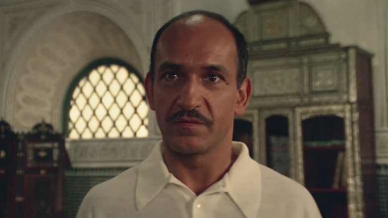 Ben Kingsley in a white shirt with a moustache