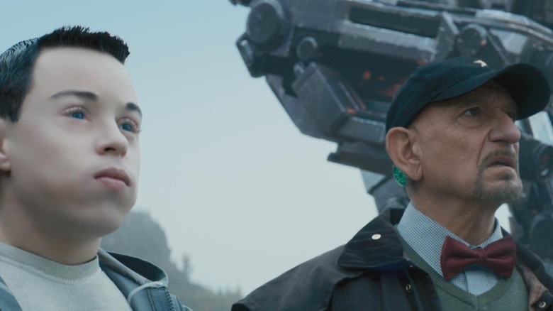 Craig Garner and Ben Kingsley standing beneath a robot