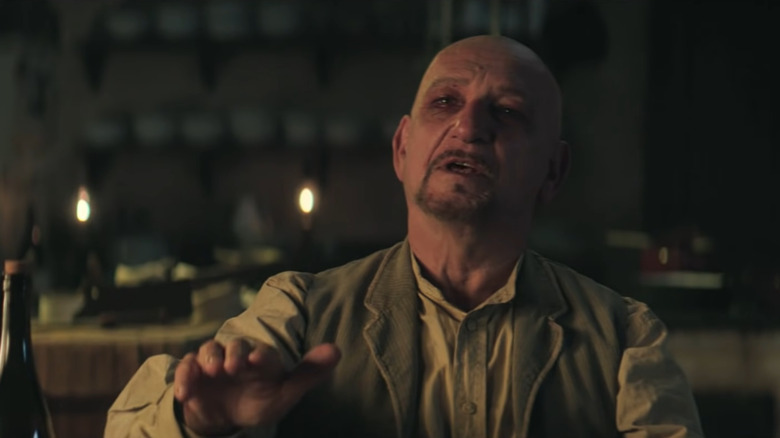 Ben Kingsley with a black eye extending his hand