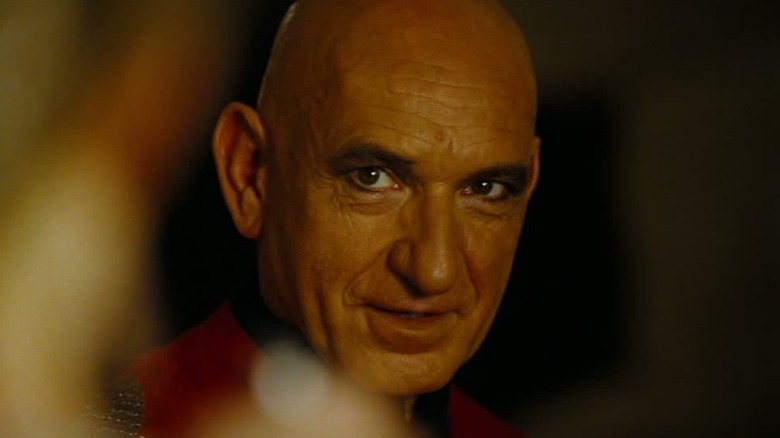 Ben Kingsley in a red robe and eyeliner