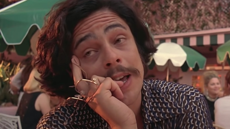 Benicio Del Toro holding glasses