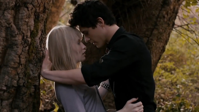 Emily Browning kissing bandmate under a tree