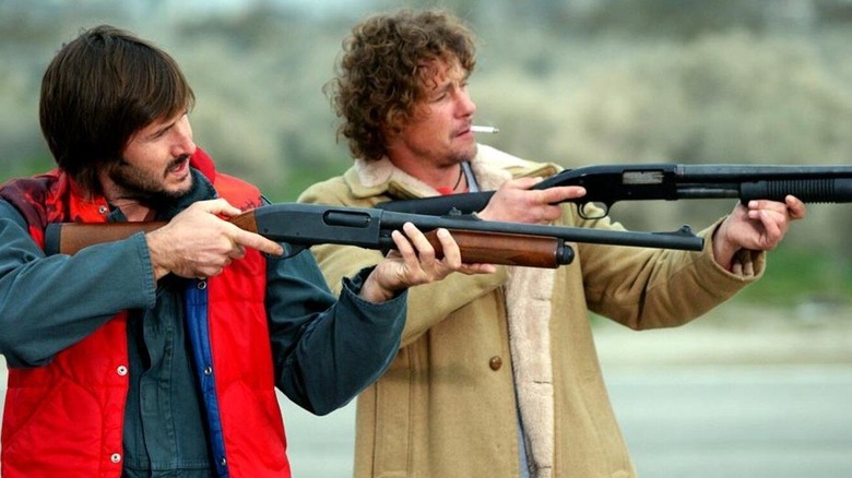 Two men hold shotguns