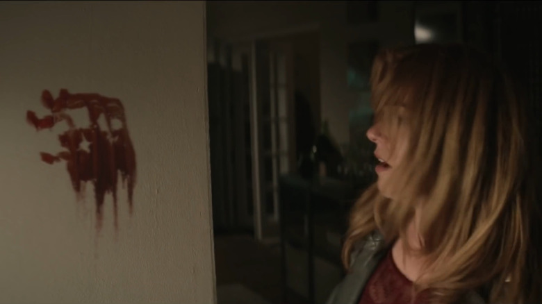 Isla Fisher scared by a bloody handprint