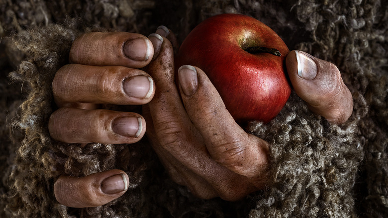 The Stranger's hands holding apple