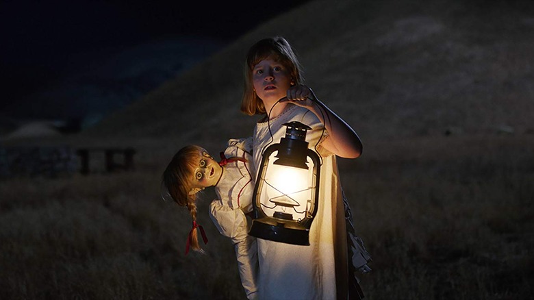 Girl holds Annabelle doll