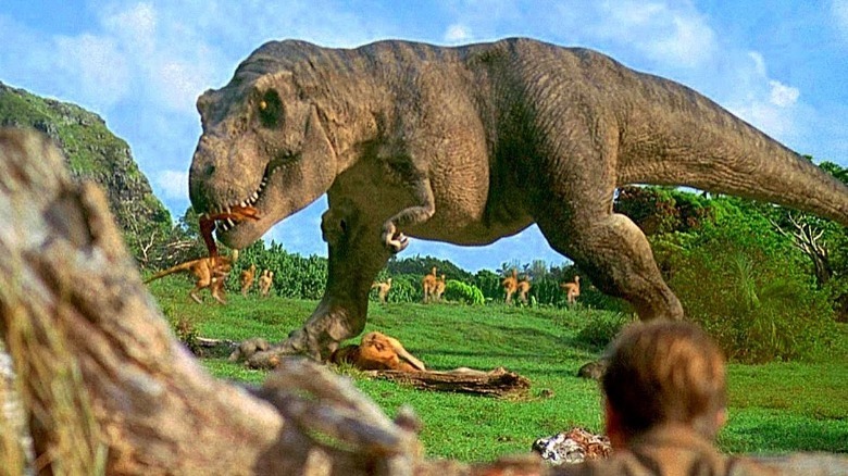 A Tyrannosaurus Rex ambushing another dinosaur