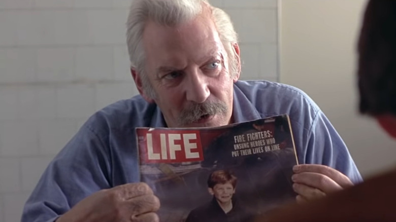 Donald Sutherland holding Life magazine