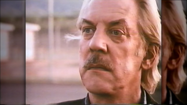 Donald Sutherland with mustache staring