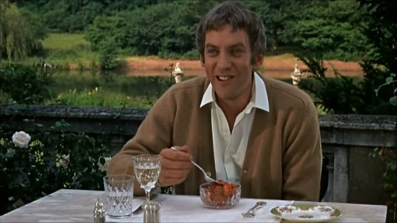 Donald Sutherland laughing and eating outside
